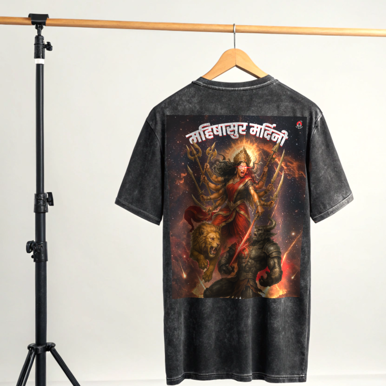 Black Acid washed t-shirt with a graphic design on a wooden hanger against a white background in a studio setup By OFF THE RACK