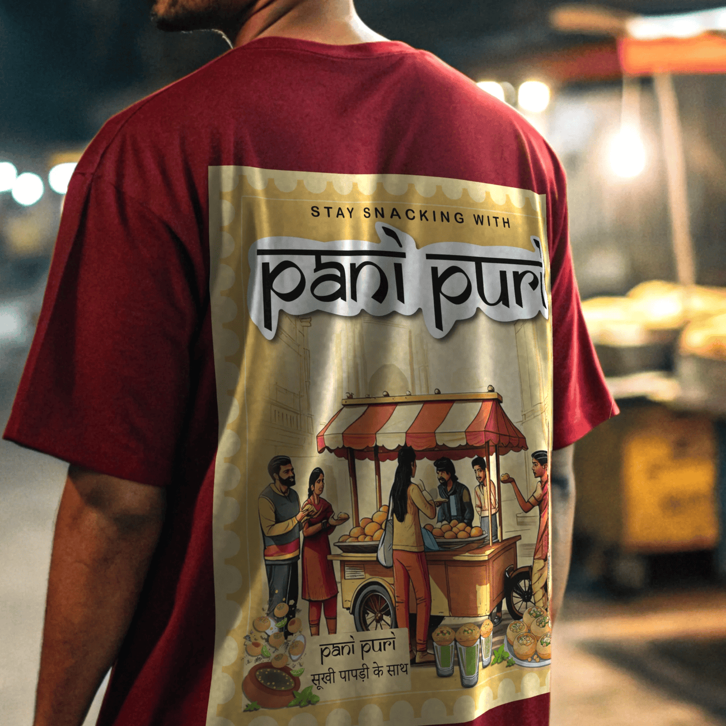 Person wearing a red t-shirt with 'pani pur' design and text in a indian street By OFF THE RACK