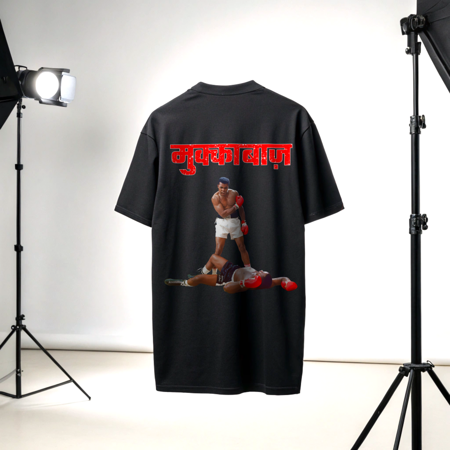 Black t-shirt with a graphic design of two boxers and MUKKEBAAZ text on the back, displayed in a studio setting with lights focused on the tshirt By OFF THE RACK
