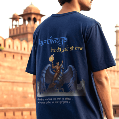 male model wearing a royal blue t-shirt with an illustration and text in front of a historical building By OFF THE RACK